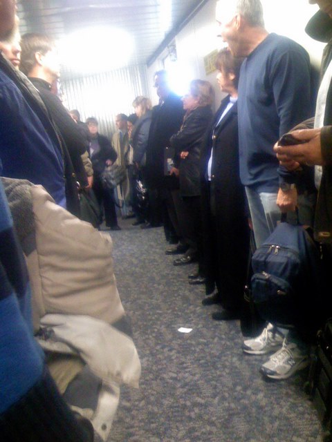 Passengers waiting for bags on a Philadelphia jet bridge